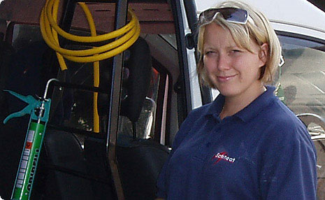 A Safeheat engineer in a branded polo shirt beside the work van